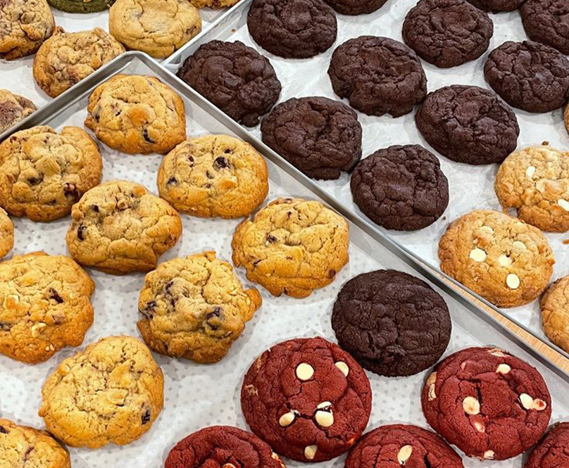 Berbagai varian New York cookies premium dengan rasa red velvet, matcha, double chocolate, dan chocolate chip di atas loyang